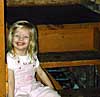 Kaylie grins while sitting on the cabin stairway